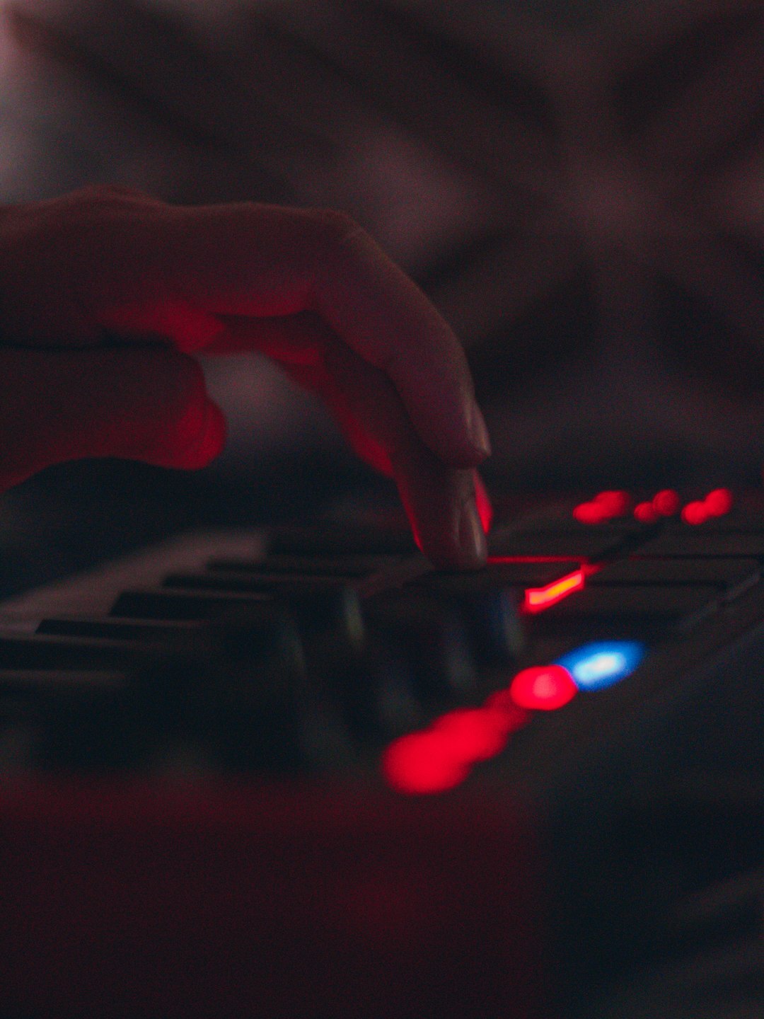 Close up of hands operating a video switcher panel with glowing buttons