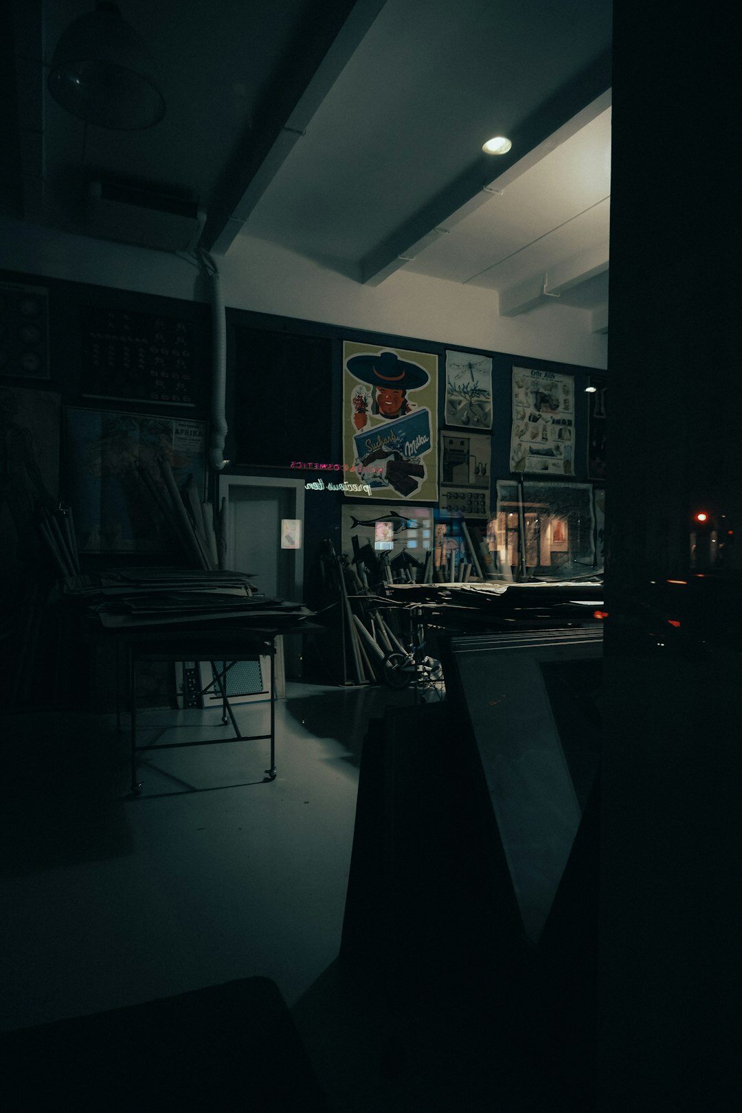 Dark moody wide shot of a broadcast control room wall of screens